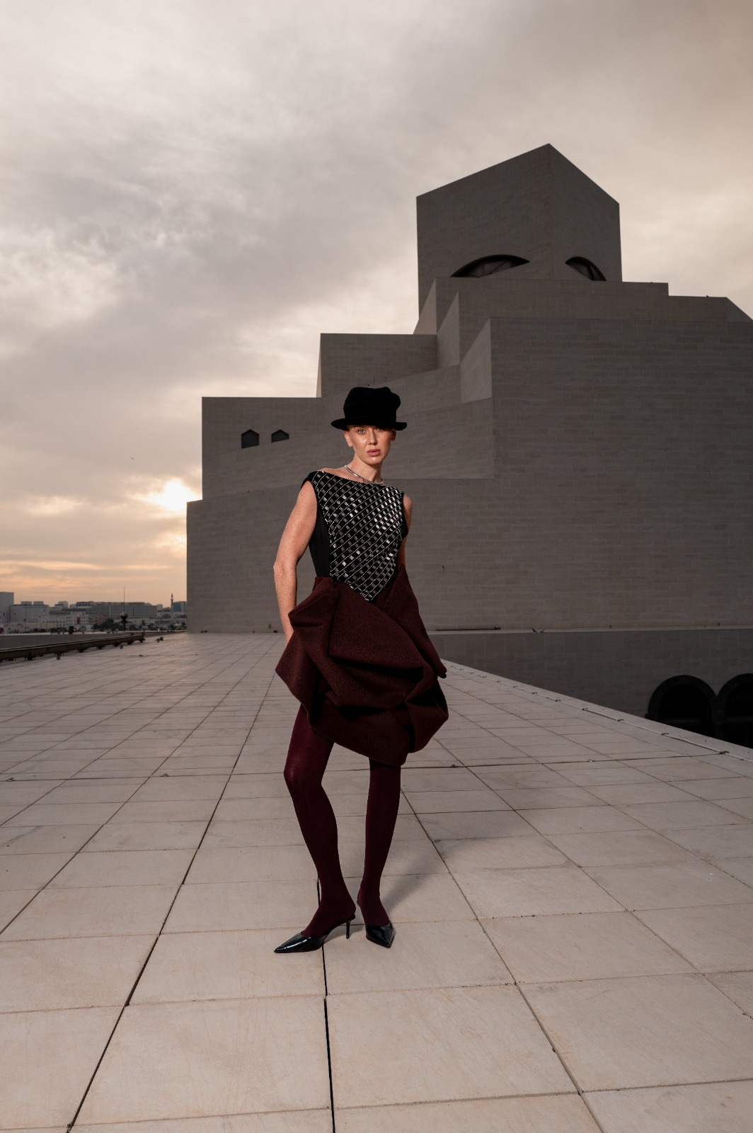 Editorial 02 — sculpted burgundy silhouette at museum